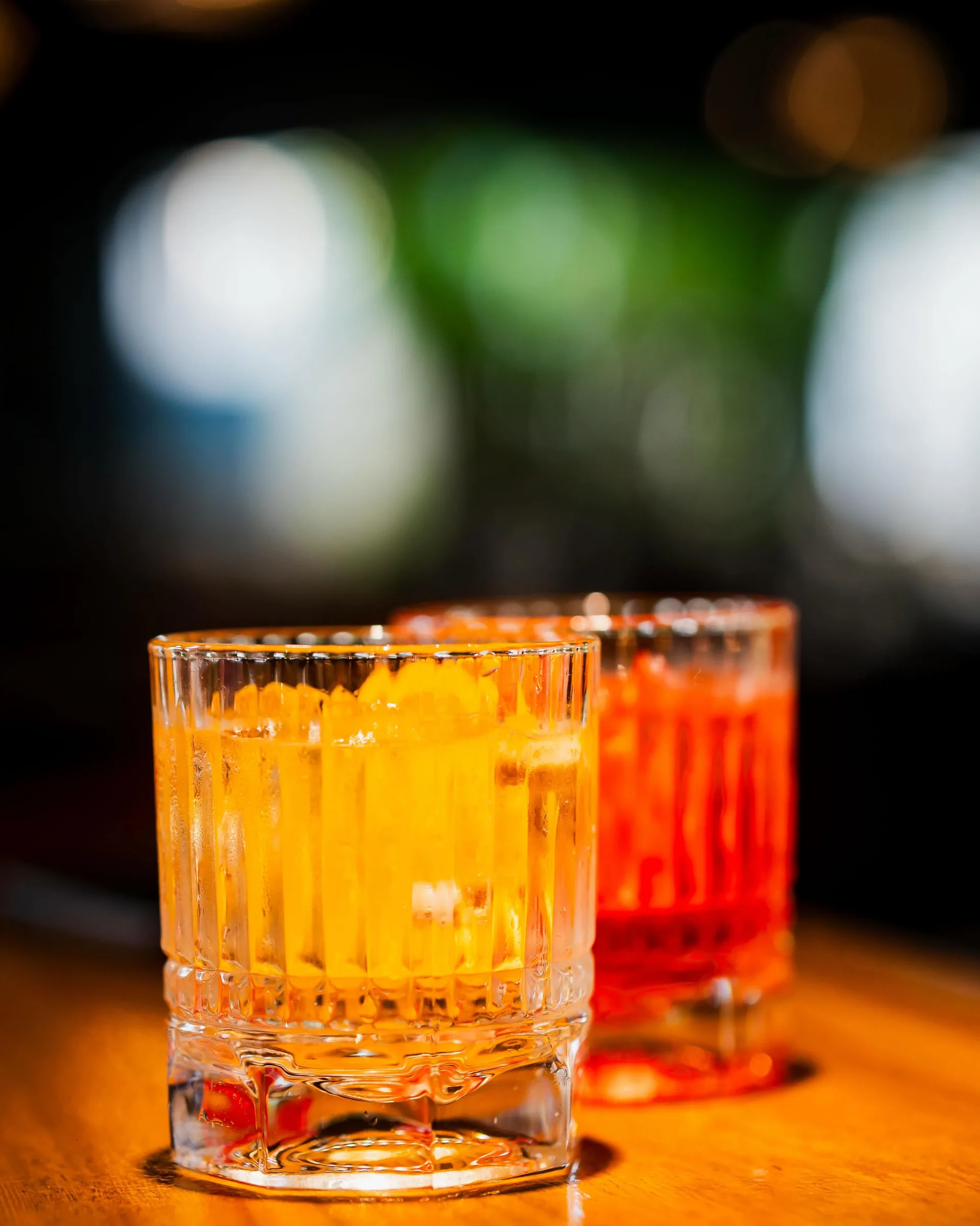 Two amber cocktails on the bar